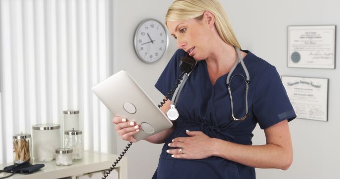 Pregnant nurse on the phone with ipad